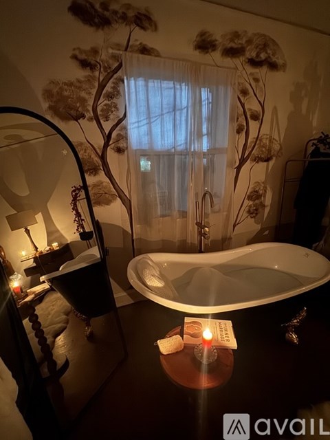 A bathroom with a large tub and a wall mural.