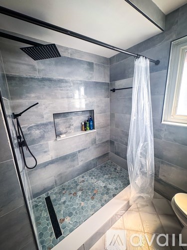 A bathroom with a shower curtain and a shower head.