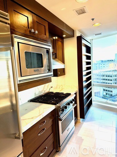 A modern kitchen with a stainless steel refrigerator and a stove top oven.