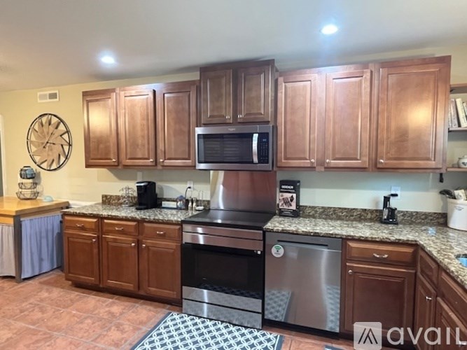 A kitchen with wooden cabinets and a stainless steel oven.