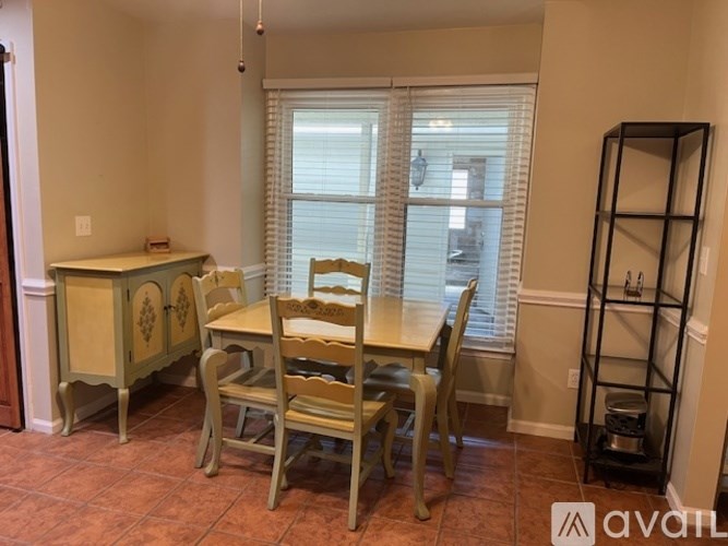 A dining room with a table and chairs.