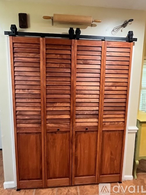 A wooden door with a roll of paper towels above it.