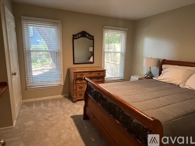 A bedroom with a bed, dresser, and mirror.