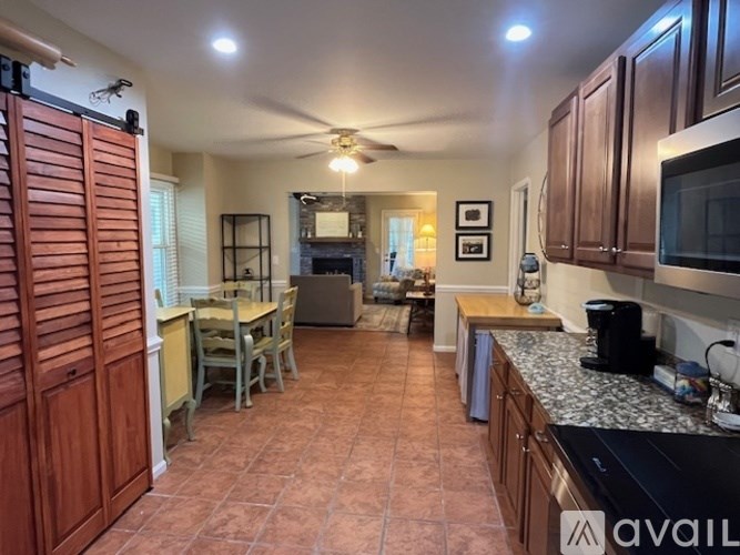 A kitchen with wooden cabinets and a tile floor.