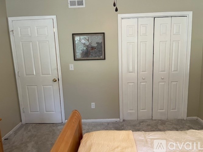 A room with two doors and a picture on the wall.