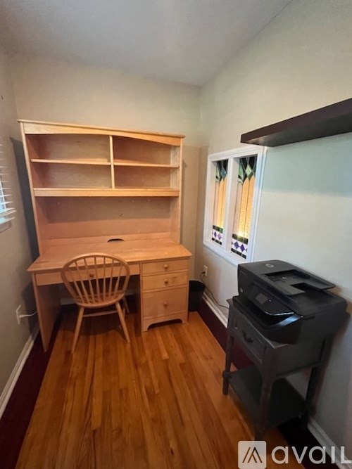 A room with a wooden desk and chair.
