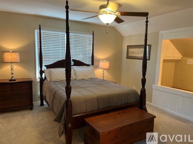 A bedroom with a four poster bed and a ceiling fan.