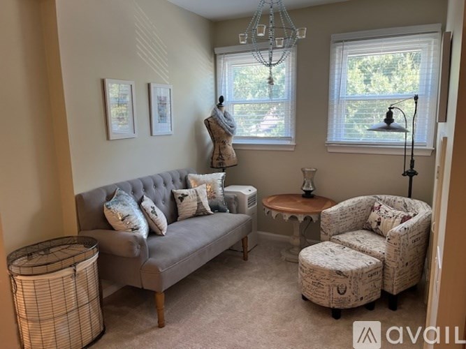 A living room with a grey couch, a chair, and a small table.