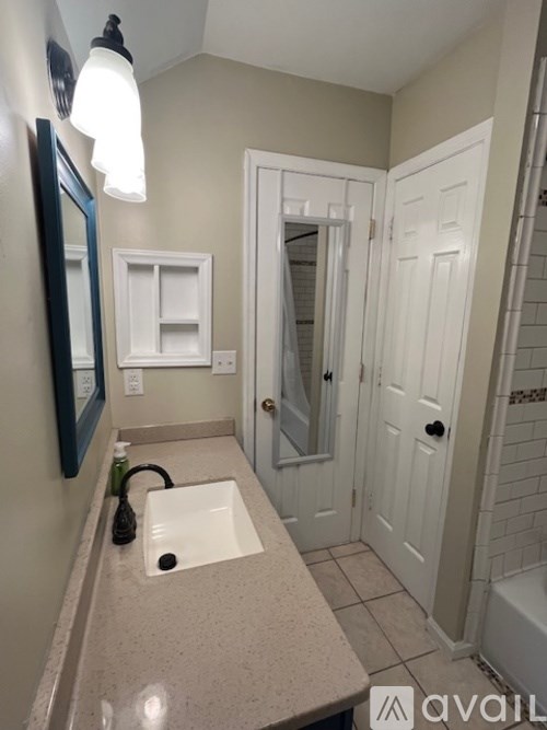 A bathroom with a sink and mirror.