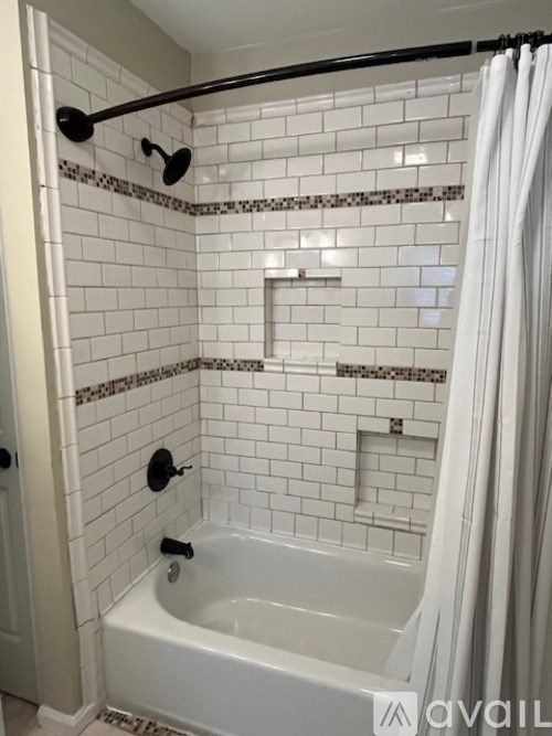 A white bathroom with a white tub and white tiles.