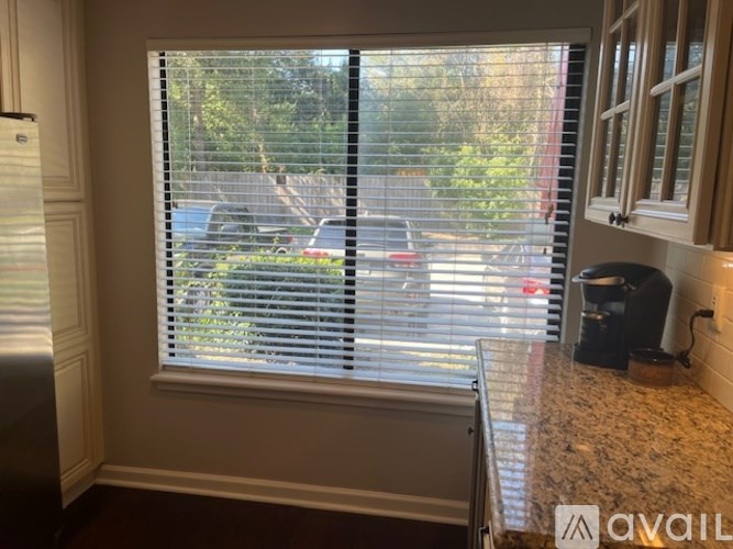 A kitchen with a window covered in blinds.