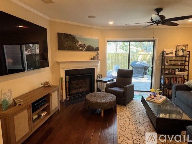 A living room with a fireplace and a ceiling fan.