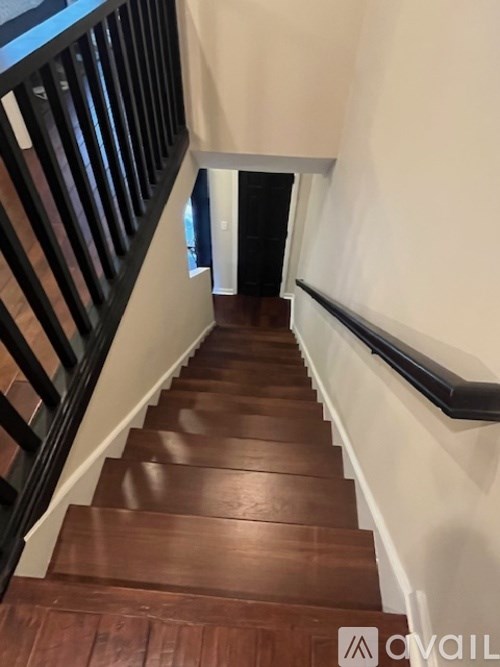 A staircase with wooden steps and a black railing.