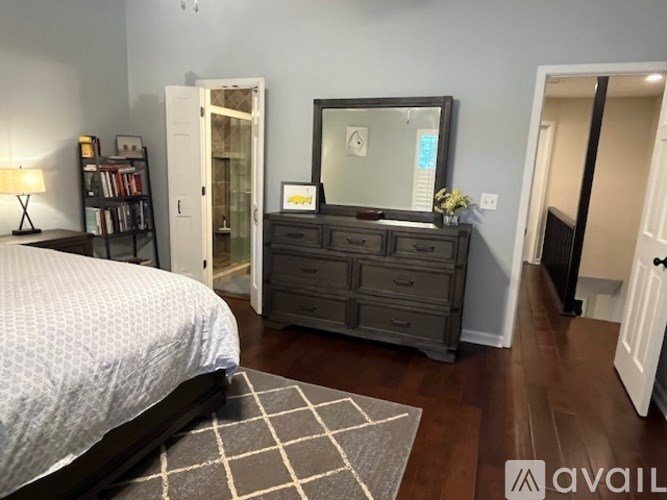 A bedroom with a bed, dresser, and mirror.