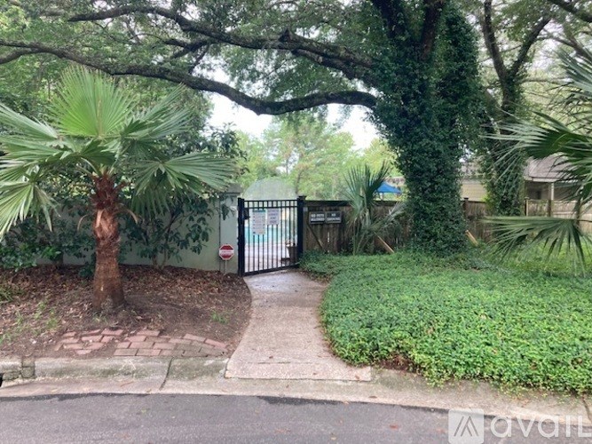 A gate with a metal fence and a tree in front of it.