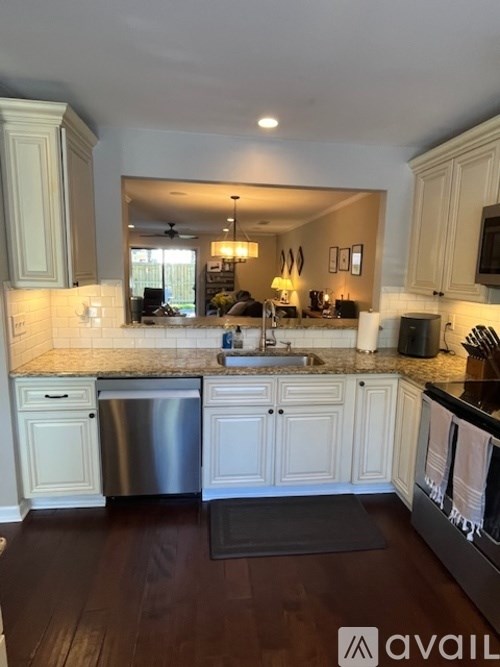 A kitchen with white cabinets and a granite countertop.