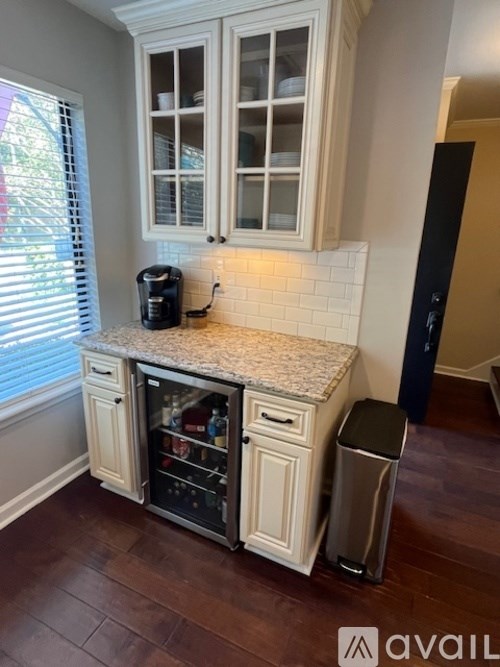 A kitchen with a granite countertop and white cabinets.