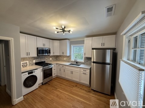 A kitchen with white cabinets and a stainless steel refrigerator.