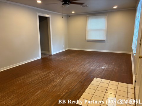 A room with wooden flooring and a ceiling fan.