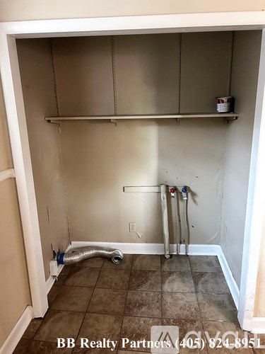 A BB Realty Partners sign is on the bottom of a small, empty room.