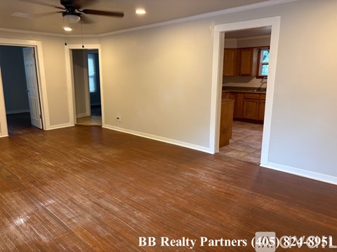 A room with a ceiling fan and wooden flooring.