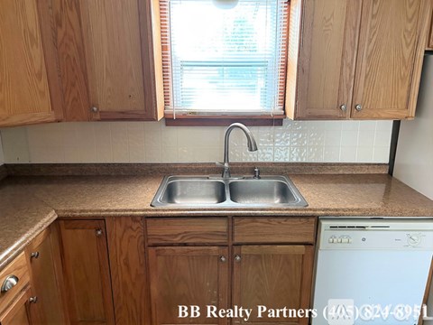 A kitchen with wooden cabinets and a washing machine.