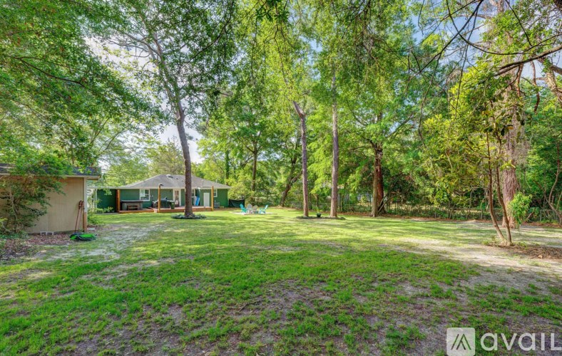 A backyard with a house, trees, and a lawn.