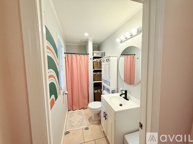 A bathroom with a toilet, sink, and shower curtain.