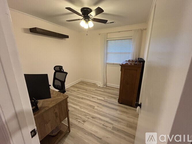 A room with a ceiling fan and a wooden cabinet.