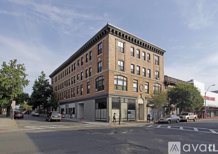 A street view of a large brick building with a clear blue sky above.