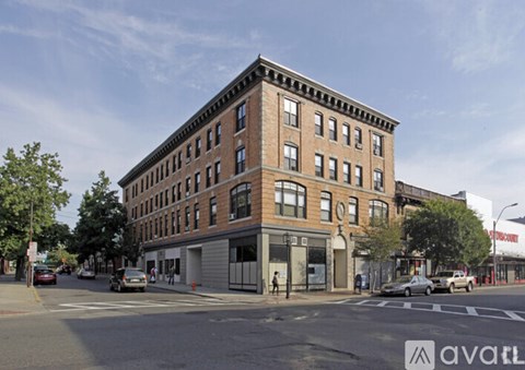 A street view of a large brick building with a clear blue sky above.