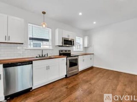 A kitchen with white cabinets and wooden countertops.