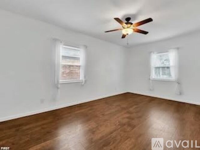 A room with wooden floors and a ceiling fan.