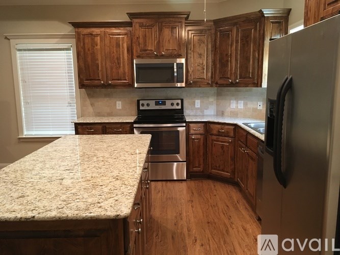 A kitchen with wooden cabinets and granite countertops.