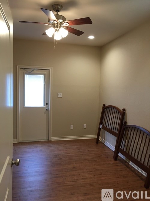 A room with a ceiling fan and two rocking chairs.