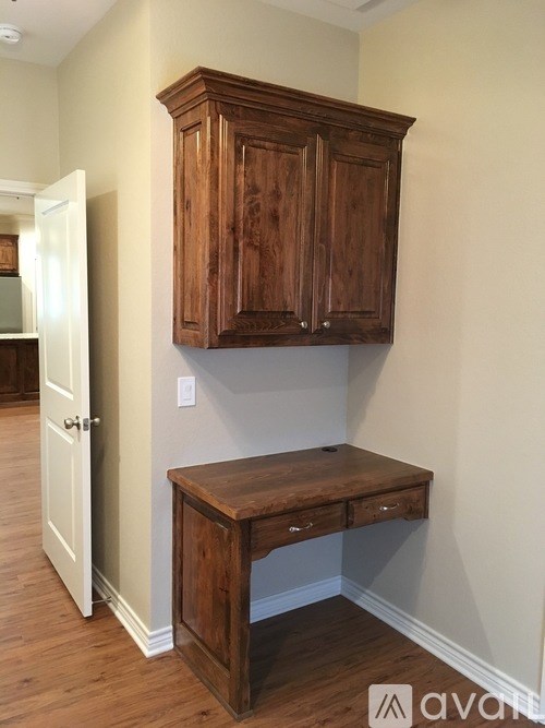 A brown wooden cabinet and desk in a room.