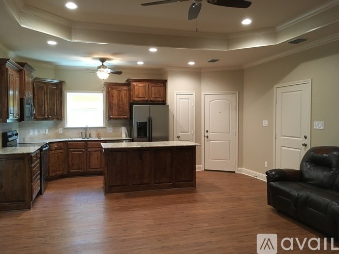 A kitchen with wooden cabinets and a black couch.