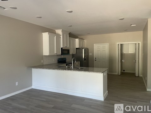 A kitchen with white cabinets and a granite countertop.