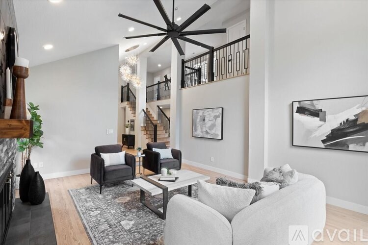 A living room with a grey couch, a coffee table, and a large black sculpture.