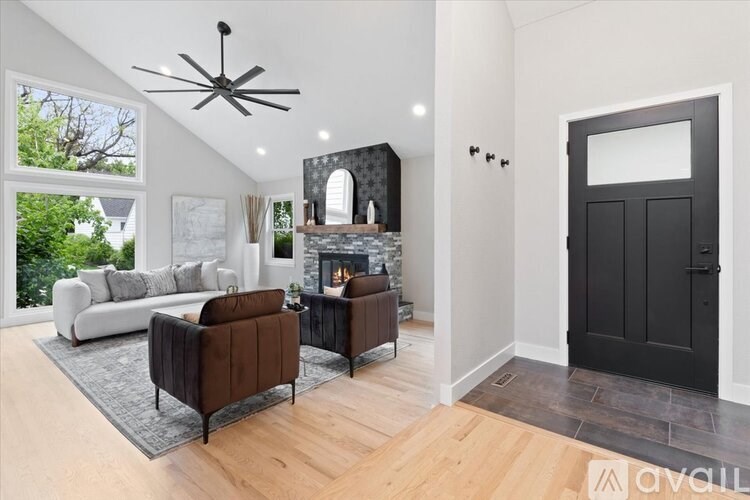 A modern living room with a fireplace and a black door.