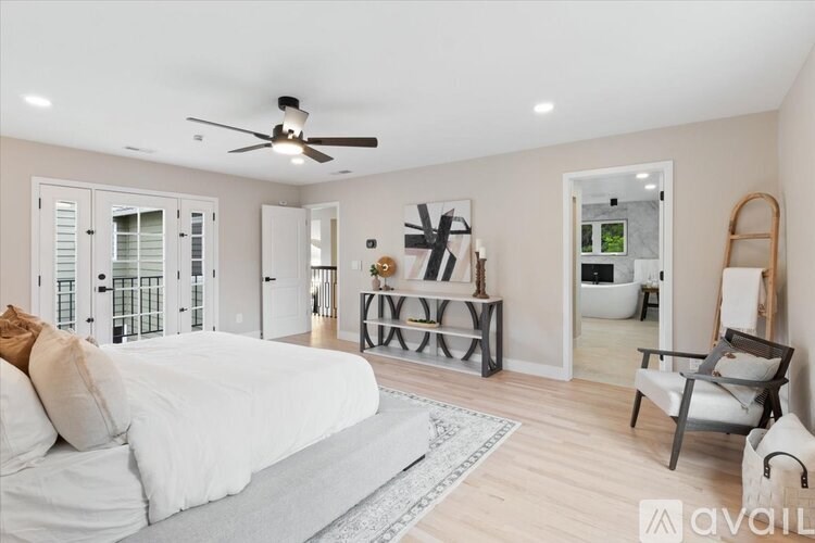 A bedroom with a bed, a chair, and a table.