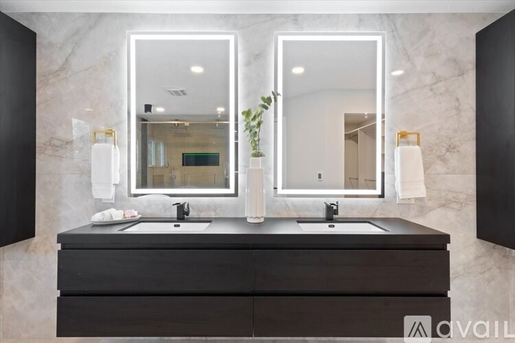 A bathroom vanity with two sinks and two mirrors.