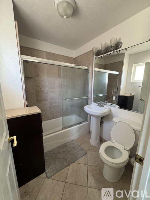A bathroom with a toilet, sink, and shower.