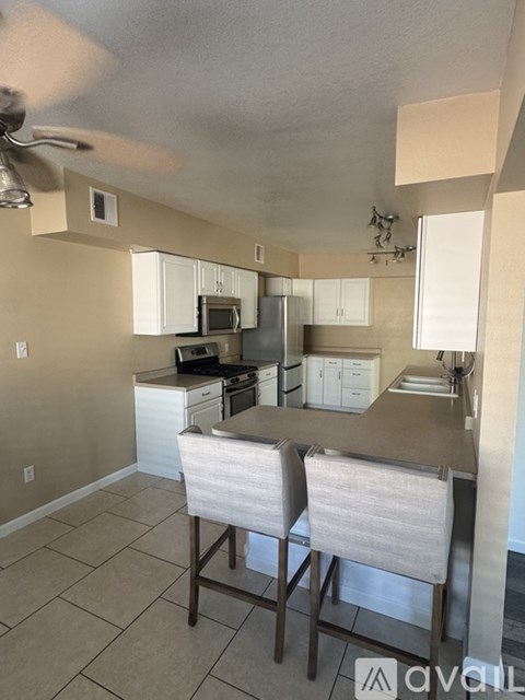 A kitchen with a table and chairs in front of it.