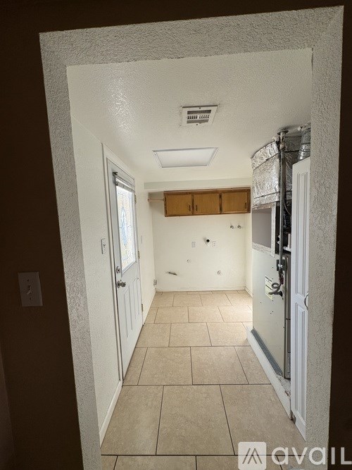 A hallway with a door on the right and a window on the left.