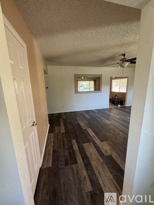 A room with wooden flooring and a ceiling fan.