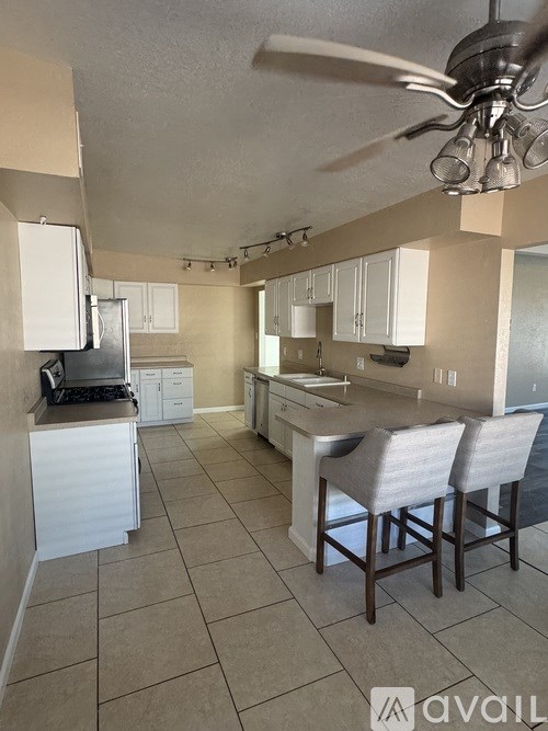 A kitchen with white cabinets and a tile floor.