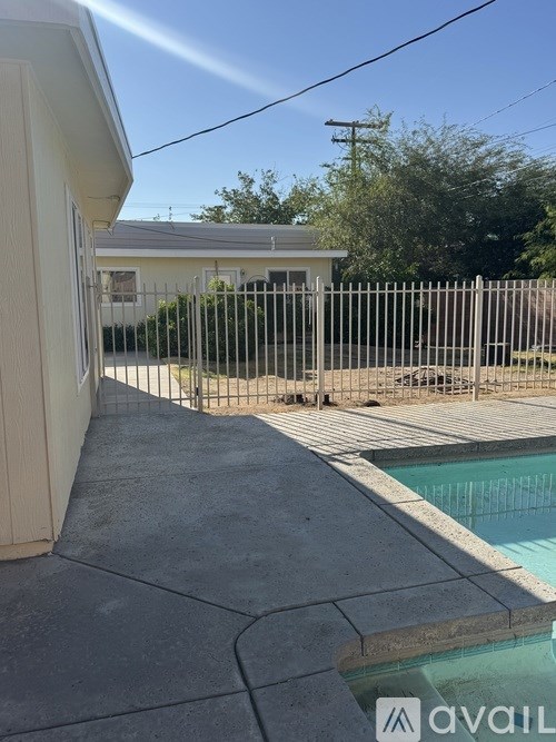 A pool area with a house in the background.