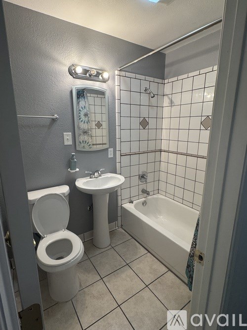 A bathroom with a toilet, sink, and bathtub.
