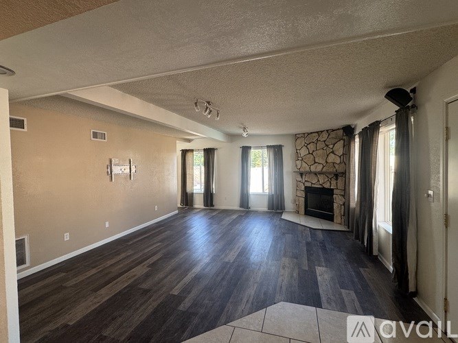 A living room with wood flooring and a fireplace.